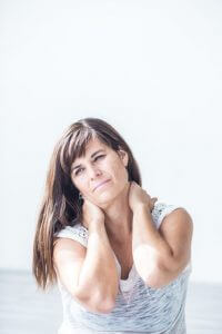 picture of a woman holding her neck in pain because of fibromyalgia