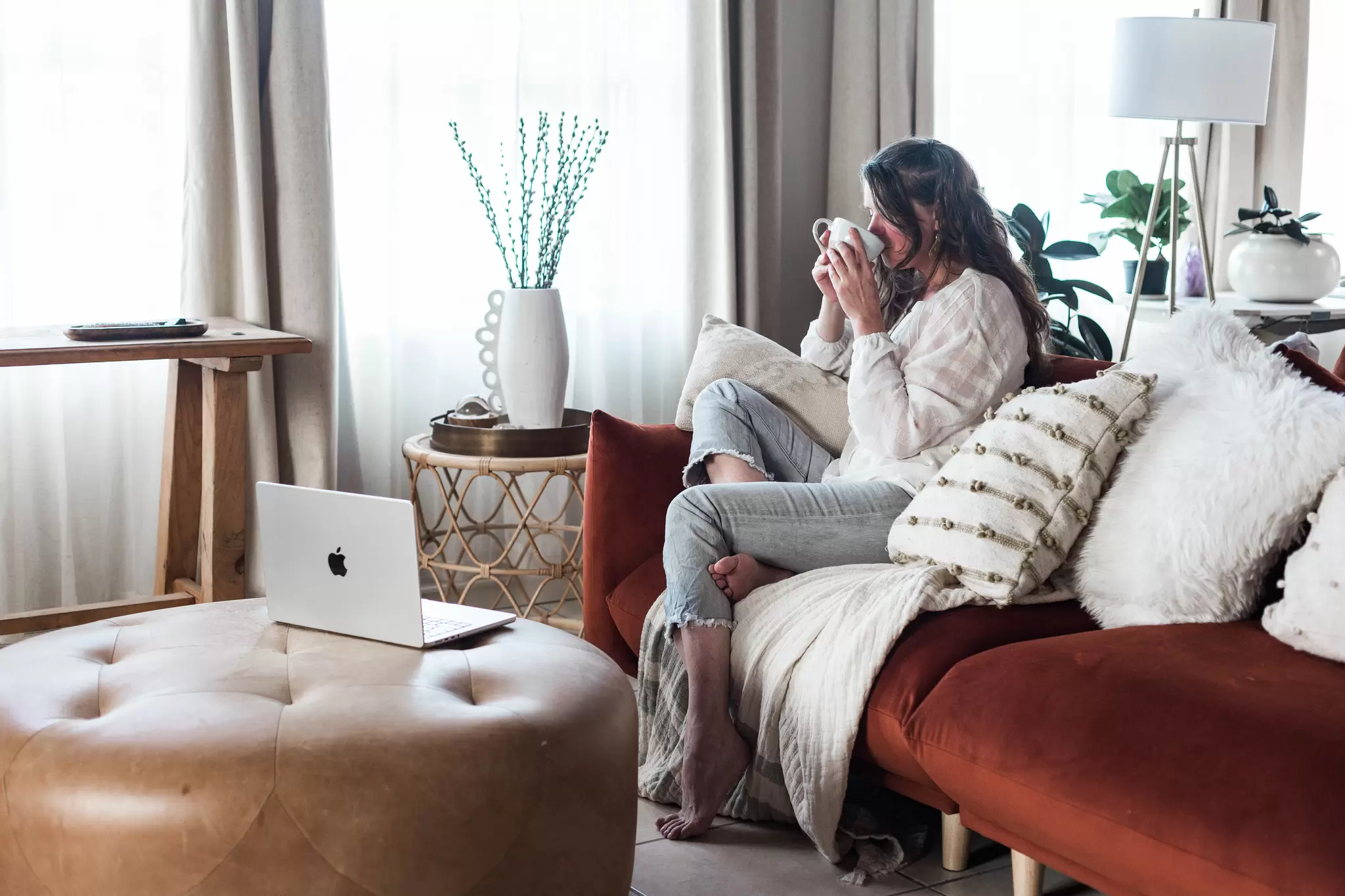 picture of a woman on a couch sipping hormone balancing tea containing individualized medicine and PCOS